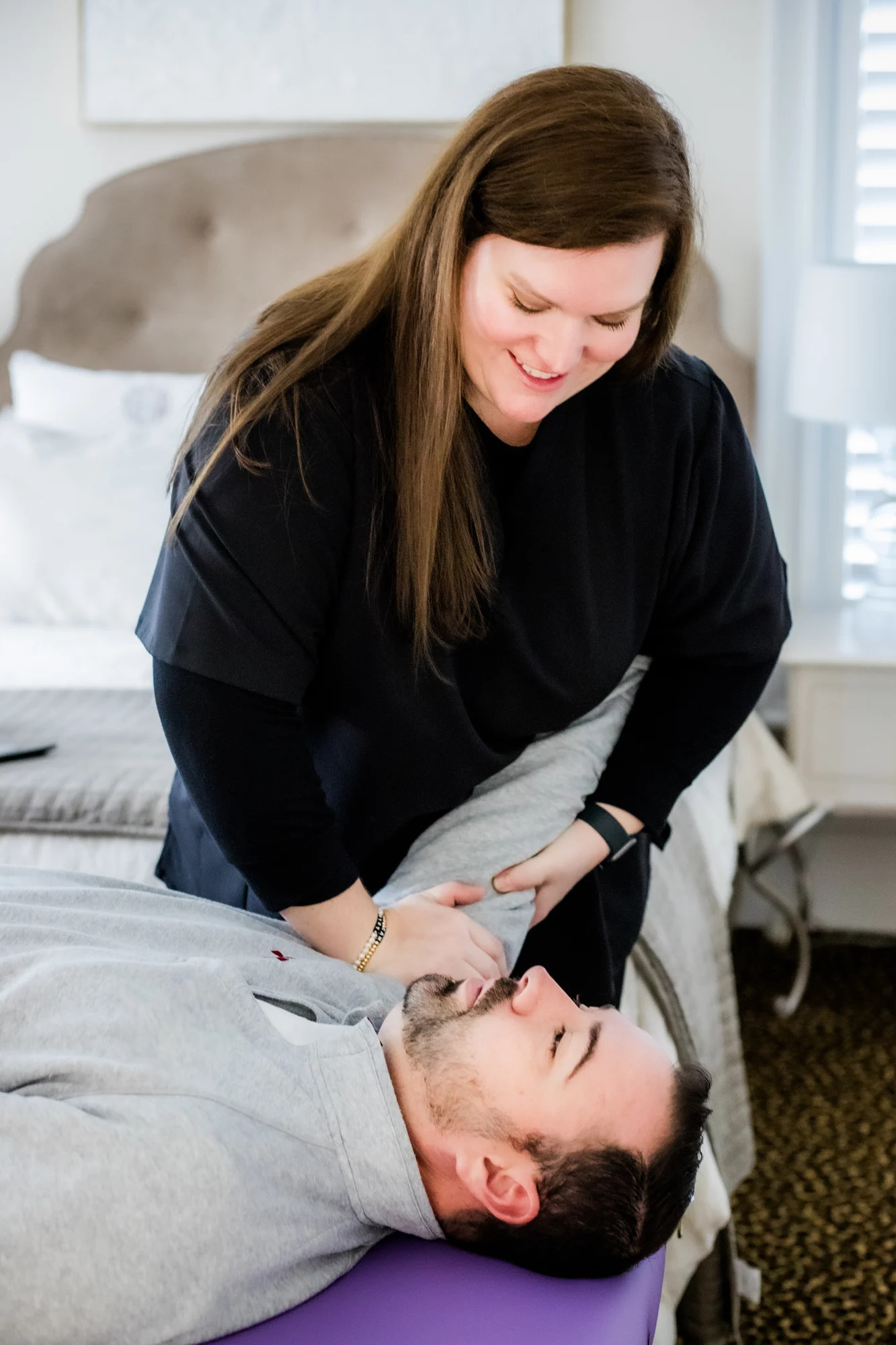 female physical therapist assisting male patient with shoulder pain