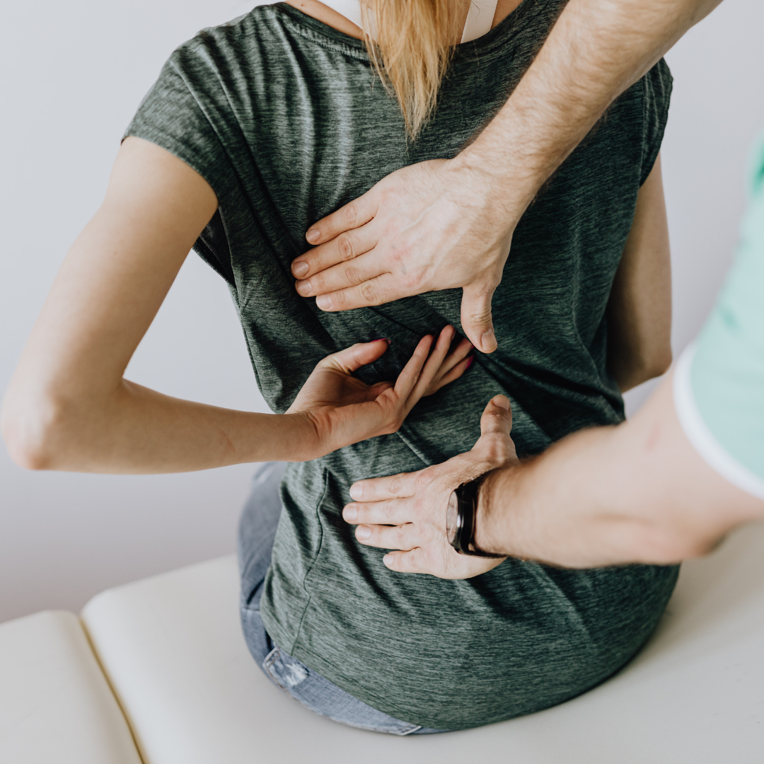 Back pain physical therapy patient pointing to area of pain